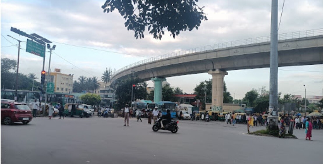 Banashankari_a crowd of people walking down a street next to a bridge