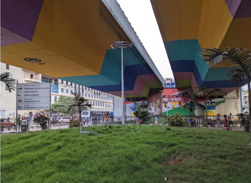Bommasandra_a green and white umbrella sitting on top of a grass covered field