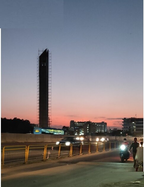 Chandapura_a city street at night with tall buildings