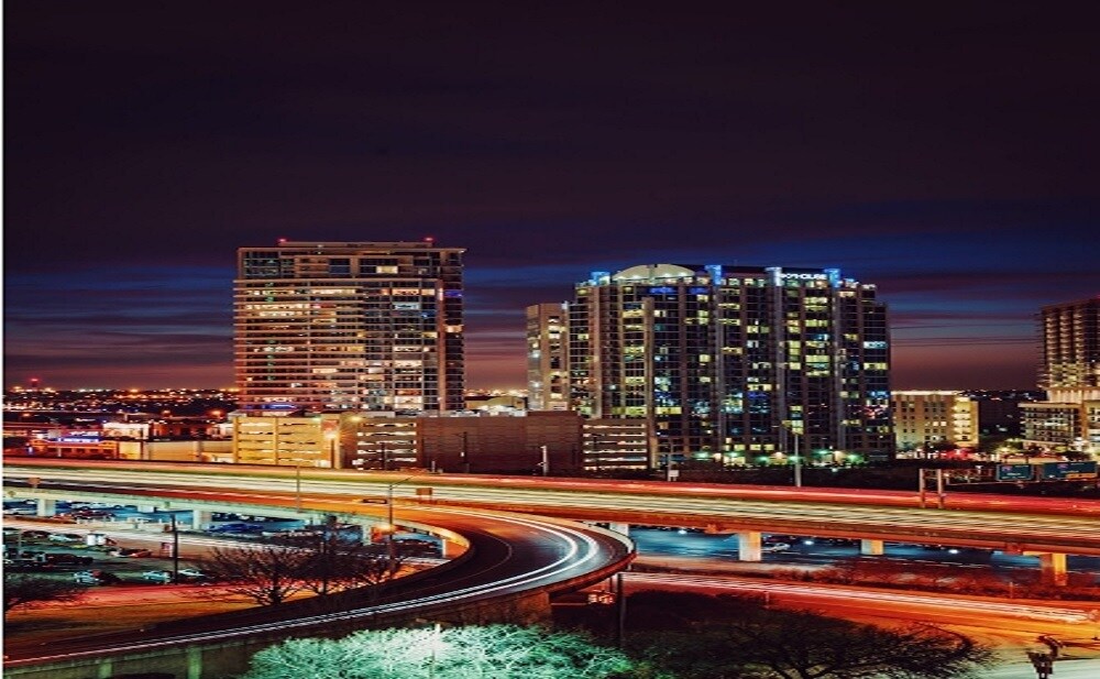 Electronic City_a city street at night with traffic lights and skyscrapers