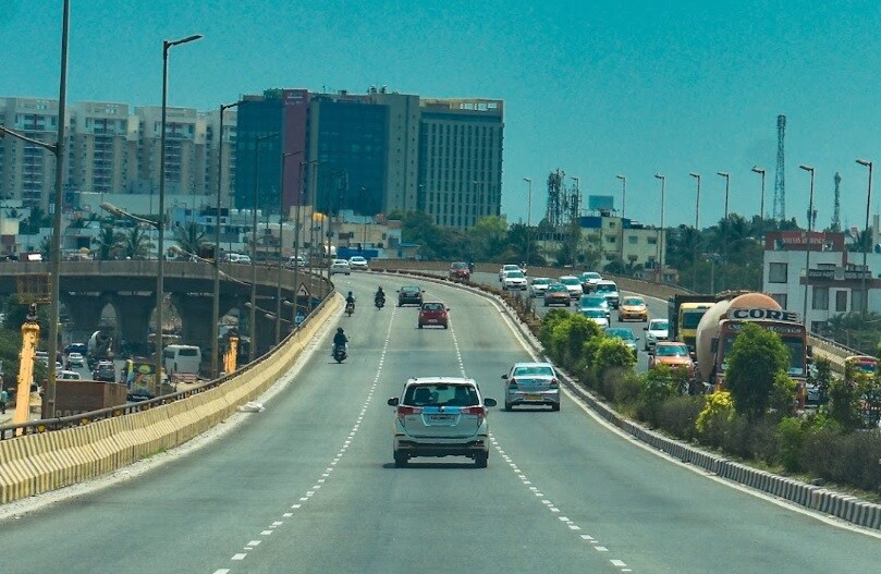 Hebbal_a car driving down a street next to tall buildings