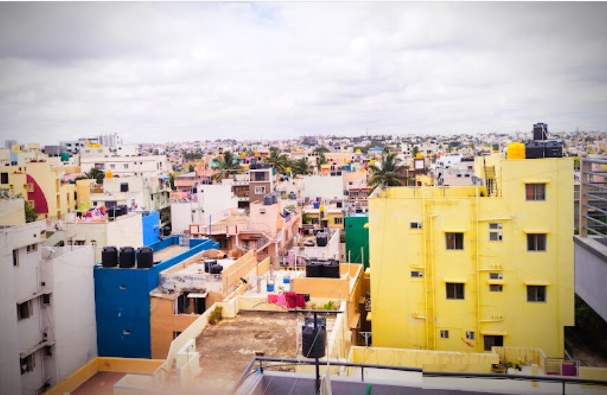 Kammanahalli_a woman standing in front of a large building