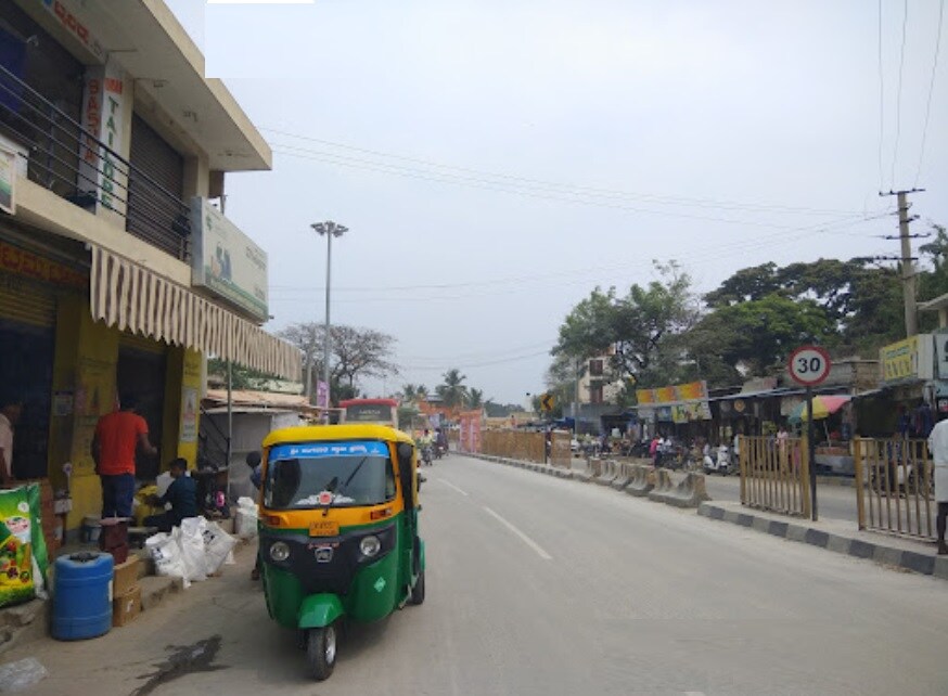 Kunigal_a green bus driving down a street next to tall buildings