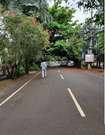 Vidyaranyapura_a man walking down a street next to trees