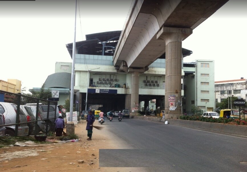 Yelachena Halli_a man walking down a street next to a traffic light
