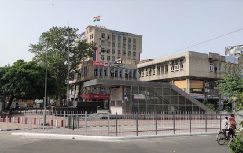 Ashok Vihar_a large building with a large clock on the side of it