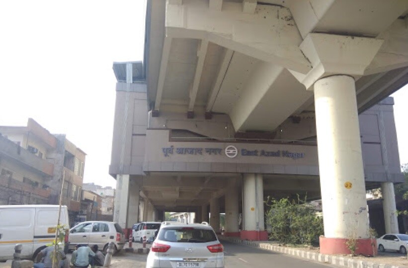 Azad Nagar_a car driving down a street next to a tall building