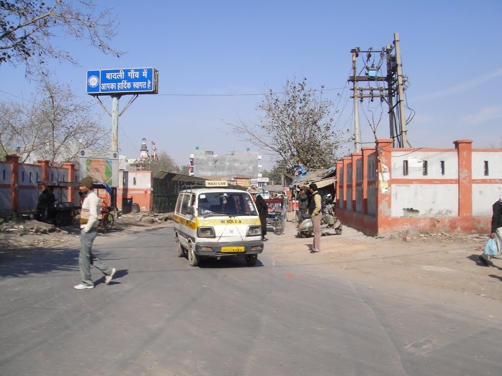 Badli_a man riding a skateboard down the middle of a street