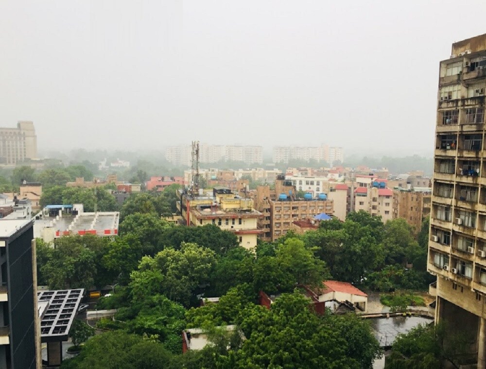 Chanakyapuri_a city street with tall buildings and a clock tower