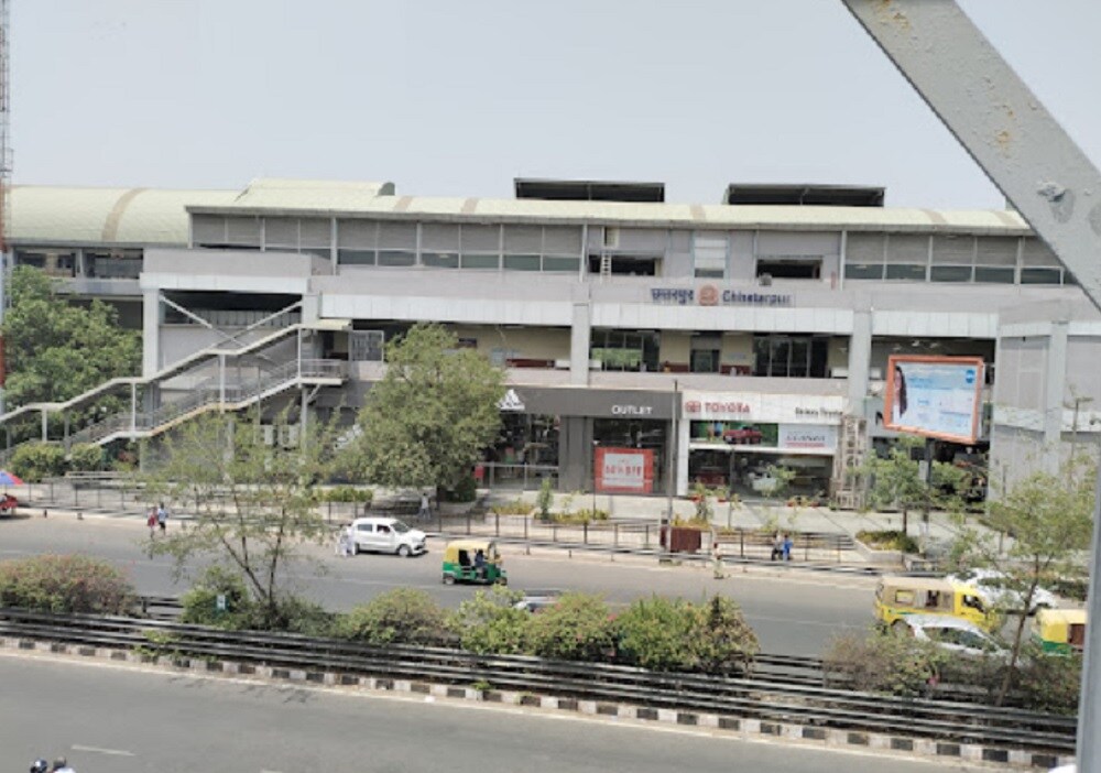 Chattarpur_a large building with a lot of cars parked in front of it