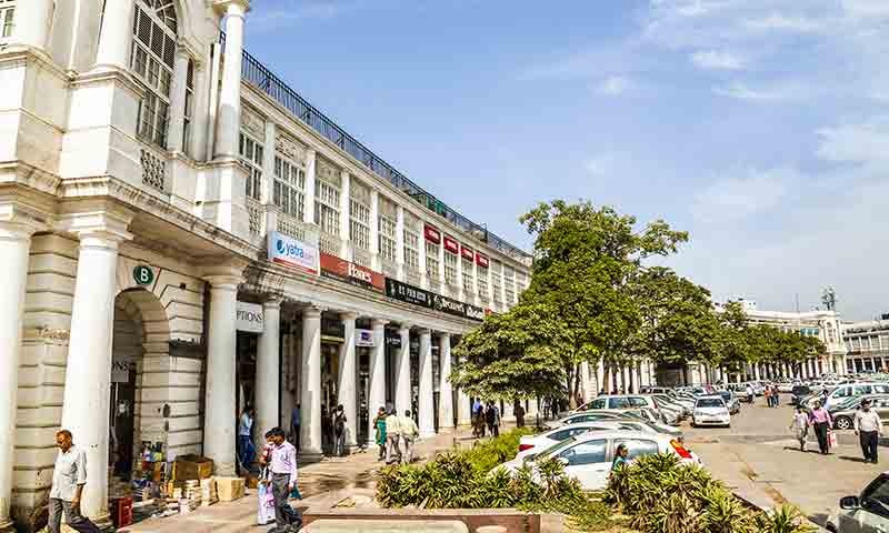 Connaught Place_people walking down a street next to a tall building