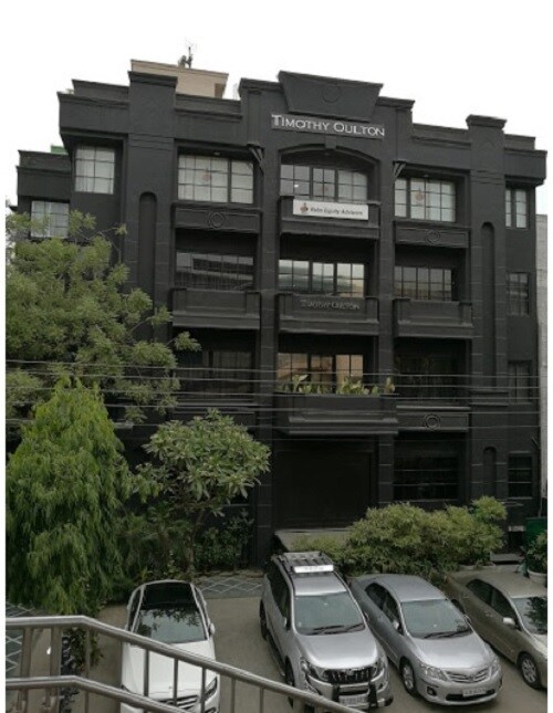 Defence Colony_a row of parked cars in front of a building