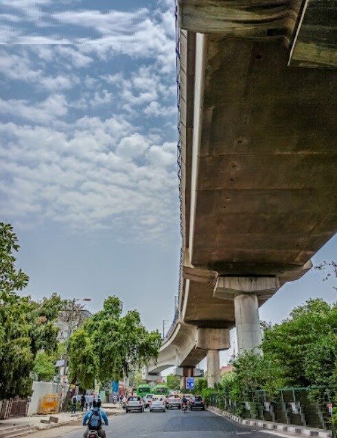 Rajendra Place_a man crossing a bridge over a street