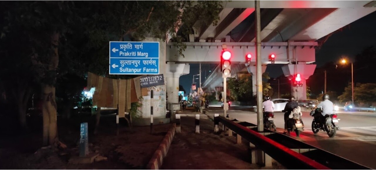 Sultanpur_a street sign at night with people walking around