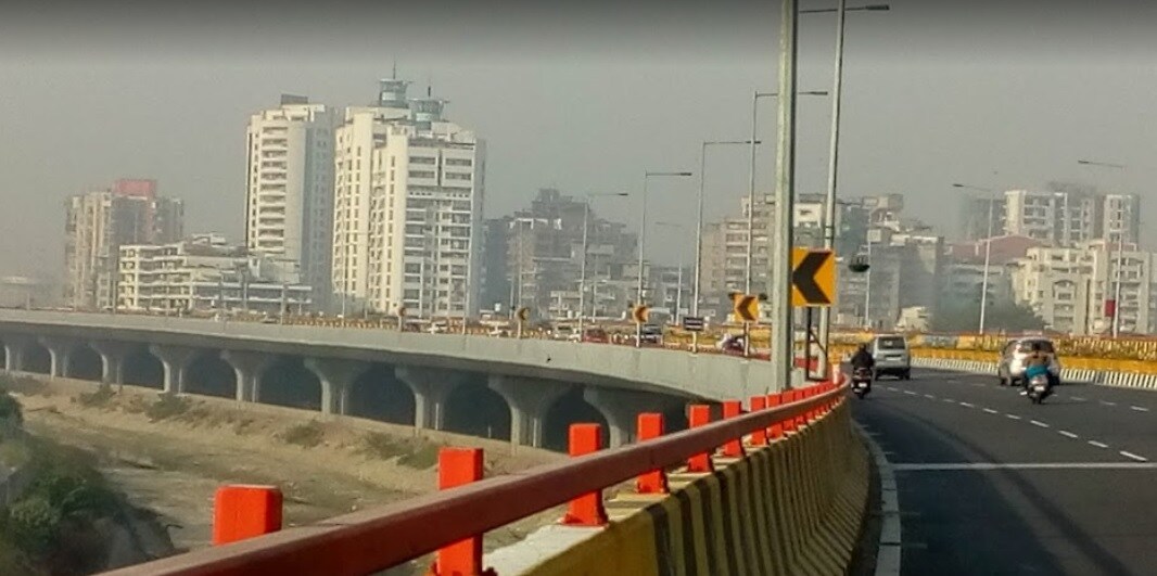 Raj Nagar Extension_a city street with a bridge over it