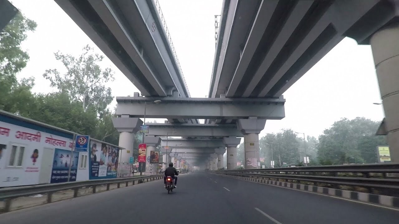 MG Road_a person riding a bike on a bridge over a highway