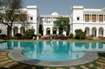 Pataudi_a large white swimming pool in front of a large building