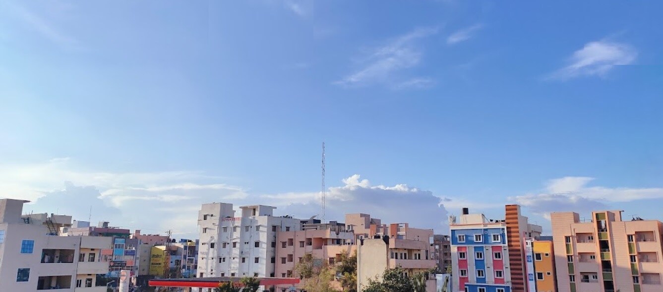 Gandi Maisamma_a city street with buildings and a sky background