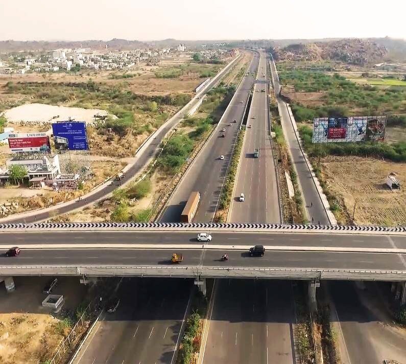 Manikonda_a highway with a train going down it