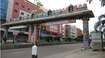 Vanastali Puram_a man standing on the side of a street next to a bridge