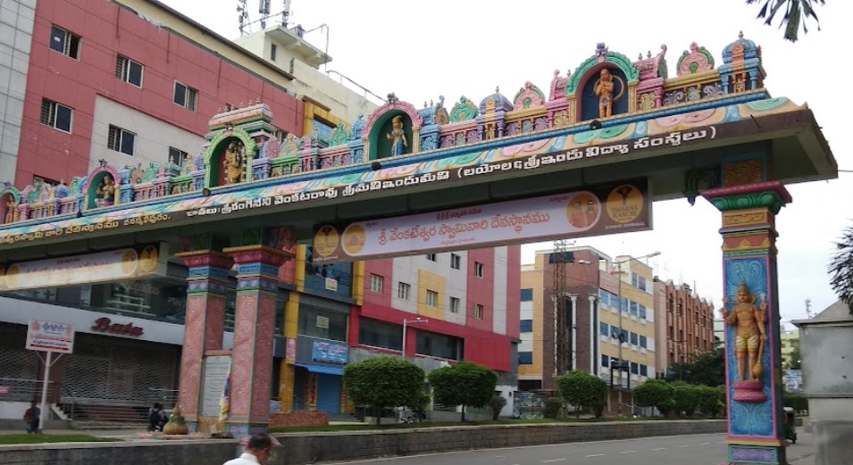 Vanasthalipuram_a man is standing on a bridge in front of a building