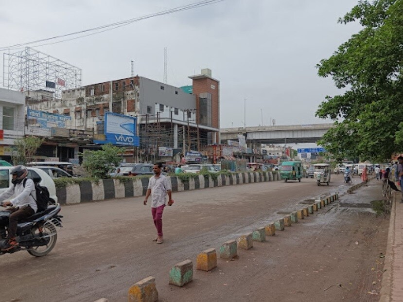 Jankipuram_a woman walking down a street next to tall buildings