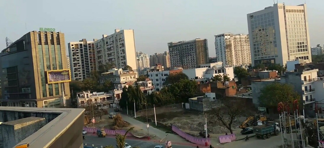 Vibhuti Khand_a city street filled with lots of tall buildings