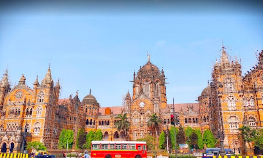 Churchgate_a red double decker bus parked in front of a church