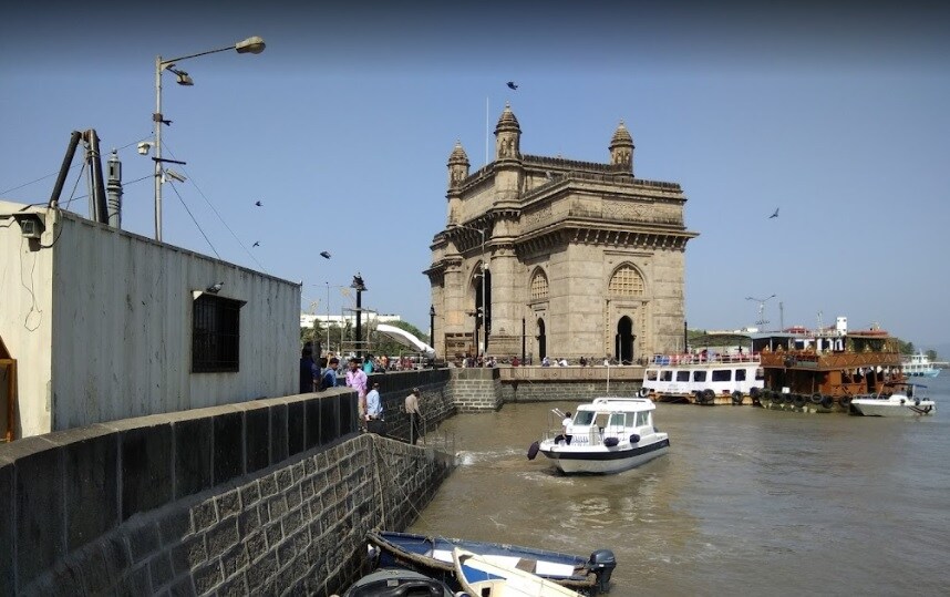 Churchgate_boats are docked in the water near a large building