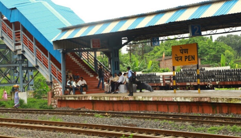 Pen_a train pulling into a train station next to a platform