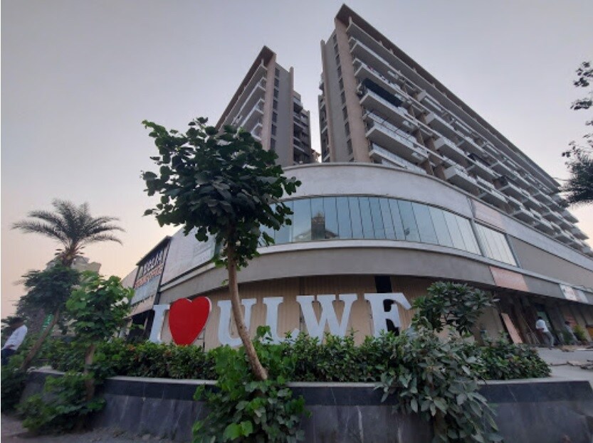 Ulwe_a large building with a large clock on top of it