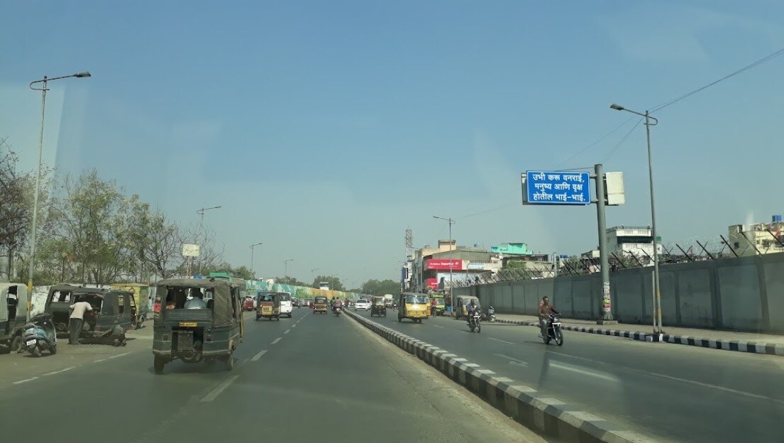 Airport Road_a city street with cars and people crossing the street