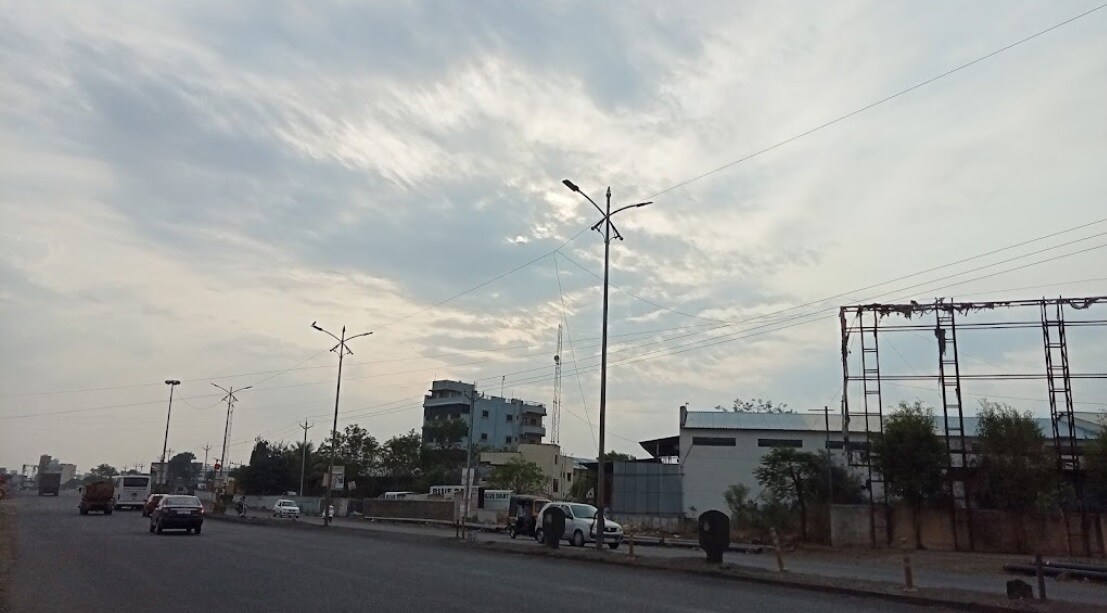 Ranjangaon_a car driving down a street next to tall buildings